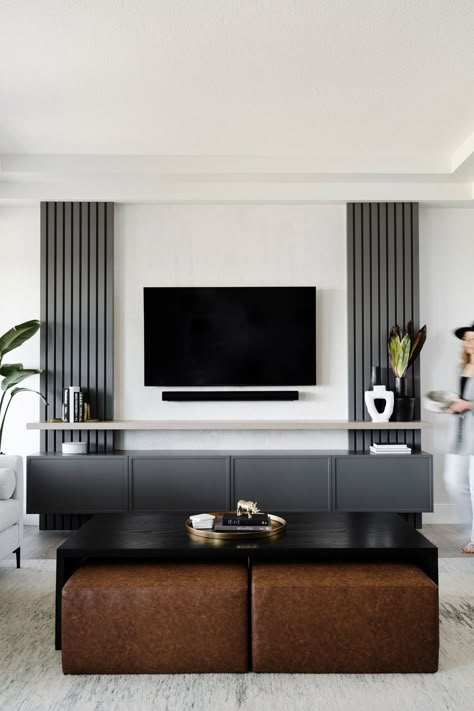 Hella Design Studio | Calgary Interior Design To give this TV wall some storage and style, we added grey slats to the wall on either side of the TV. A black floating media console and shelf top off the space. 📷: @heymjay Design Tv Wall, Tv A Muro, Tv Wall Panel, Tv Wall Ideas, Black Feature Wall, Feature Wall Living Room, Tv Stand Decor, Floor Renovation, Modern Tv Wall