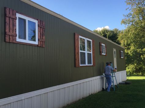 Single Wide Paint Exterior, Trailer House Remodel Single Wide Outside, Diy Single Wide Trailer Remodel, Trailer Colors Exterior, Trailer Remodel Single Wide Diy Exterior, Trailer Updates Mobile Homes, Black Underpinning Mobile Home, Single Wide Trailer Remodel Exterior, Mobile Home Fireplace Remodel