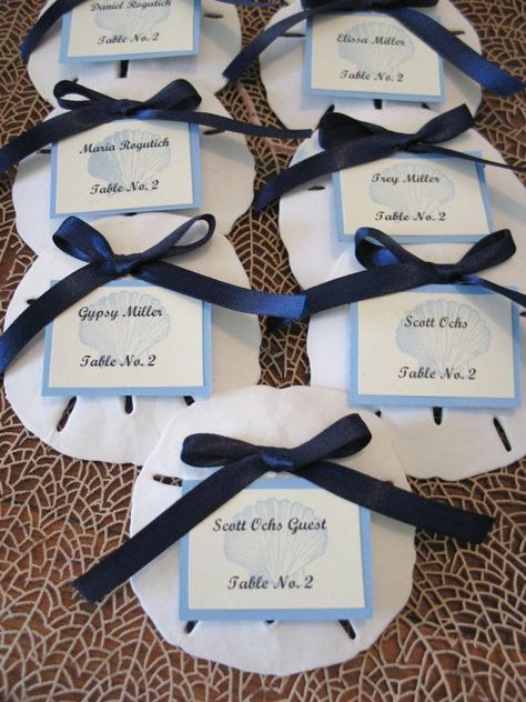 white oversized seashells made of clay, with navy bows and blue and white cards are very stylish and timeless for a nautical wedding Sand Dollar Wedding, Table Assignments, Beach Wedding Guests, Wedding Sand, Table Place Cards, Dinner Decoration, Beach Wedding Decorations, Beach Wedding Favors, Wedding Order