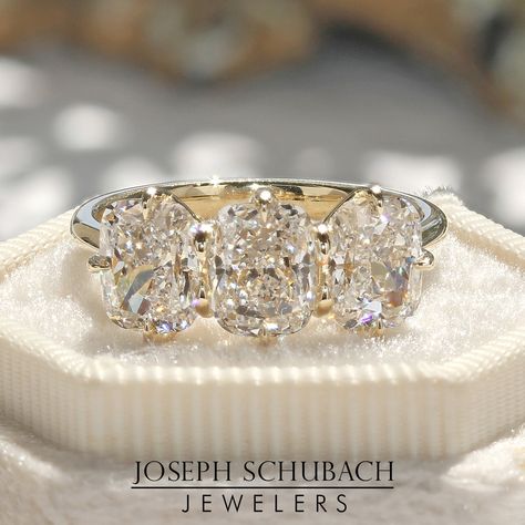 A Joseph Schubach design. This three stone ring features three Radiance® lab grown modern cushion cut diamonds weighing 3.27ct in total. Each stone is G color and VS2 clarity and is accompanied by a GCAL certificate. The setting is crafted in 14kt yellow gold and is available to ship. Contact us for additional info. Cushion Trilogy Ring, 3 Stone Anniversary Ring, Cushion Cut Eternity Band, Three Stone Ring With Wedding Band, 3 Stone Ring, Three Stone Ring, Resetting Diamonds Ideas, Oval Three Stone Ring, 3 Diamond Engagement Rings