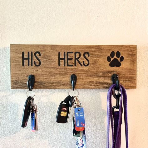 **Please note that each key holder is unique and the photo shown is just an example of what you will receive. Due to it being handmade, it is not guaranteed that it will look 100% exactly the same, though the text and dog paw is traced using the same reference each time**  ✷ handmade 14" x 5" (1" thickness) woodburned his & hers key and dog leash holder ✷ your choice of natural wood or stained wood (color: jacobean) ✷ finished with a polyurethane clear coat to seal and protect  ✷ black zinc 1.57" hooks  ✷ 2 D-rings are screwed onto the back for easy hanging on the wall His Hers Dog Key Holder, Diy Wood Pet Projects, Key And Leash Holder, Dog Home Decor Ideas, Key Holder Wall Decor, Customized Wood Gifts, Home Decor For Couples, Keys Storage Ideas, Cute House Warming Gifts