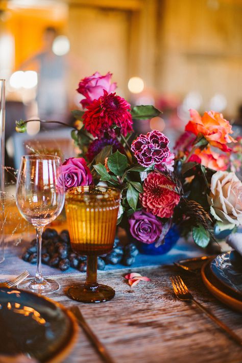 Ruby, amethyst, and sapphire hues may feel luxe, but Lale Florals proved that they work for rustic weddings, too. The pros arranged this unique centerpiece of red and purple roses and dahlias, which popped against the raw wood tables. Topaz glassware and sapphire vases ensured every gemstone color was represented. Dahlia Centerpiece Wedding, Peonies Wedding Centerpieces, Pop Wedding, Lush Wedding, Lighted Centerpieces, Jewel Tone Wedding, Boda Mexicana, Jewel Wedding, Deco Floral