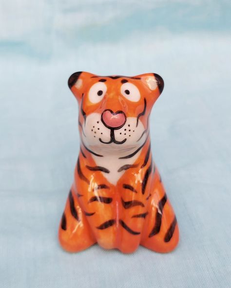 Wide-eyed tiger 🐯✨ My animal figurines have slightly evolved over time and this is my most recent ceramic tiger sculpture. His eyes are shiny, bright and filled with wonder. This brave little tiger is the most perfect desk companion. Place him in your workspace and watch him cheer you on! 🐅 Available on our website | www.jungleparade.com Clay Tiger, Cheetah Ceramic, Tiger Incense Holder, Tiger Sculpture, Tiger Ceramic Sculpture, Tiger Statue, My Animal, Perfect Desk, Animal Figurines