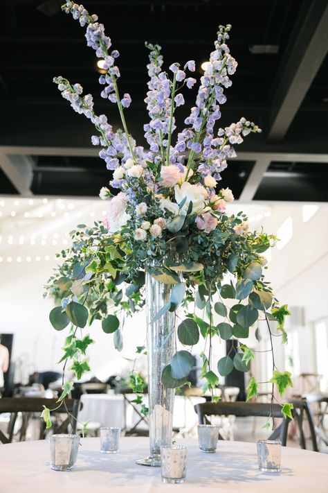 Tall and luxurious centerpieces with delphinium blue! Venue: The Cordelle. Planning: Randi Events. Photography: SheHeWe Photography. Florals: Enchanted Florist TN Blue And White Tall Centerpiece, Delphinium Table Arrangement, Delphinium Centerpiece Wedding, Tall Wedding Table Centerpieces, Delphinium Wedding Flowers, Tall Flower Arrangements Wedding, Delphinium Centerpiece, Delphinium Wedding, Tall Vase Arrangements