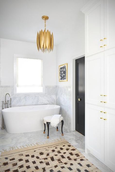 A gold leaf chandelier hangs over a freestanding oval bathtub accented with a floor-mount gooseneck tub filler placed under a window. Freestanding Tub Ideas, Bathtub Under Window, Small Freestanding Tub, Bathroom Architecture, Tuscan Bathroom, Bathroom Chandelier, Standing Tub, Bathroom Cabinets Designs, Tub Ideas