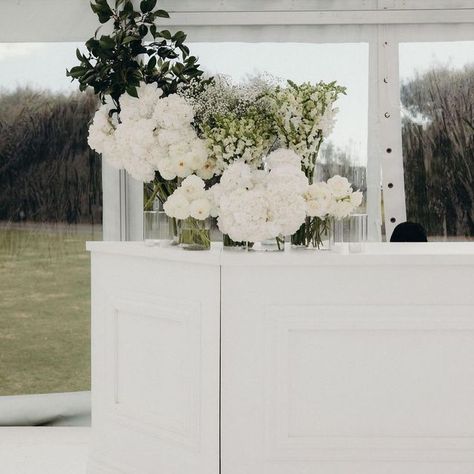 Twelve Tables Marquee & Furniture on Instagram: "< a few of David + Lara’s T. details • Our white framed bar with corners, two tiered signage frame(designed & built for D + L ), bridal feature wall, beaut big clear marquee and our white wooden flooring • all captured by 📸 @jesseandjessieweddings at @abbevilleestate • with the amazing @greatcatering @lalumiere_nz @blush_flowers @harlancreative @societyofloves & @trishpeng >" Modern Black And White Wedding Flowers, Wedding Vase Decor, Bar Florals Wedding, Simple Elegant Wedding Table Decor, Black And White Garden Wedding, White Wooden Flooring, Black Accent Wedding, Bar Florals, Twelve Tables