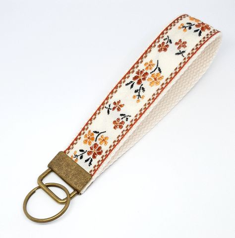 "Go hands free with this vintage floral style key wristlet!  Available in the standard length to fit over your wrist, or in a mini size which can loop onto your finger or act as a stylish keyring! Made from a vintage style jacquard ribbon and canvas webbing with metal hardware in a bronze finish.  Available in two colour ways.  DIMENSIONS ------------------- Standard: 14.5cm (5.5\") L x 25mm W (circumference 24cm) Mini: 10cm (4\") L x 25mm W (circumference 15cm) (Length measurements include height of hardware *There may be slight variations in sizing since each product is handmade but we make every effort to ensure accuracy and consistency between our products. Due to the handmade nature of the product, pattern placement may vary from the display photo. Also, colours can appear differently Cute Key Lanyard, Cute Wristlet Keychains, Key Lanyard Aesthetic, Car Keychain Aesthetic, Car Keys Keychain Ideas, Stocking Stuffers Women, Small Wallets For Women, Key Wristlet, Car Accessories Diy