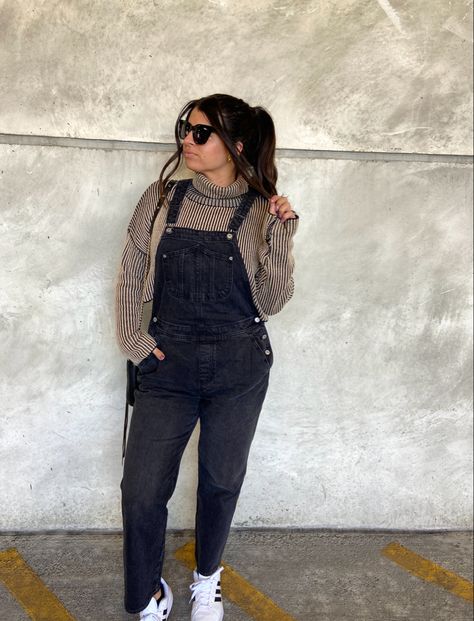 Brunette in high pony with quay sunglasses, brown cropped turtleneck sweater, black old navy overalls, and white adidas superstar sneakers Corduroy Overalls Outfit Winter, Maternity Black Overalls Outfit, Jacket Over Overalls, Overalls And Sweatshirt, Black Overalls Sweater Outfit, Flannel Overalls Outfit, Black Overalls Outfit Winter, How To Style Overalls, Overalls With Sweater