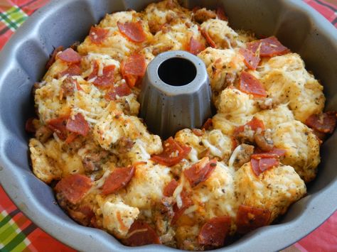 Easy Pull Apart Pizza Bread *2 (14 oz.) cans of Pillsbury pizza dough (you can use Grand biscuits) *2 cups shredded Mozzarella cheese *1/2 tbsp. basil leaves *1/2 tsp. dried oregano *1/2 tsp. fresh minced garlic *1/3 cup olive oil *1 (8 oz.) package of pepperoni (cut into quarters) *1 cup Parmesan cheese Pull Apart Cheese Bread, Pillsbury Pizza, Pizza Monkey Bread, Pull Apart Pizza, Pull Apart Pizza Bread, Pizza Bread Recipe, Bread Packaging, Canned Biscuits, Pull Apart Bread