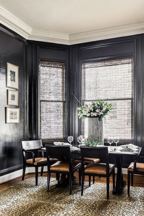 The dining table, surrounded by black chairs with seats covered in caramel-hued leather, is framed by the windows in the dining room. All by Liaigre from De Sousa Hughes. The bold leopard-print rug by stark is the perfect addition to add levity to the space. Photographer: Christoper Stark Breakfast Nook Rug, Nook Curtains, Breakfast Nook Curtains, Leopard Rug, Grey Design, Banquette Seating, Wooden Side Table, Luxe Interiors, Interiors Design