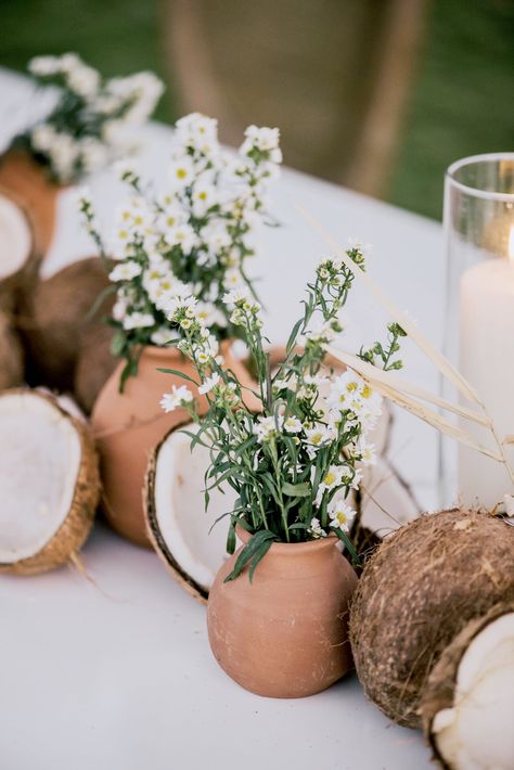 broken coconuts, terra cotta pots, and white floral table decor Coconut Floral Arrangement, Tropical Wedding Ideas, Harvest Tables, Coconut Decoration, Event Centerpieces, Private Resort, Bohemian Weddings, Reception Bride, Bridesmaid Dresses Under 100