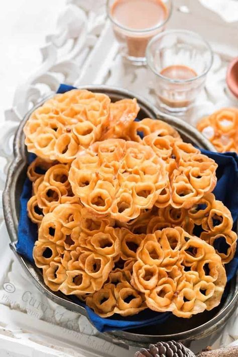 Rose cookies aka achu murukku is a traditional South Indian snack made during festivals in India. The pretty flower shape makes these murukku or cookies a very popular snack and goes perfectly with your evening tea. Festivals in India are always grand and colorful. That goes not just for clothes and decorations but for all the festive delicacies as well. Deepavali/Diwali is one of the grandest festival of lights in India and downright it’s one of my most favorite festival. I literally wait all y Sambhar Recipe, Rosette Cookies, South Indian Snacks, Flower Desserts, Rose Cookies, Popular Snacks, Indian Dessert Recipes, South Indian Food, Christmas Food Desserts