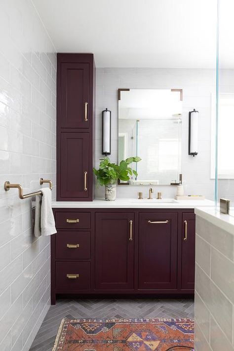 Aubergine painted washstands with brass pulls topped with a white quartz countertop and a brass faucet. Wine Color Bathroom Ideas, Wine Color Bathroom, Aubergine Paint, Burgundy Bathroom, White Vessel Sink, Lacquered Walls, Herringbone Wood Floor, Purple Bathrooms, Herringbone Floor