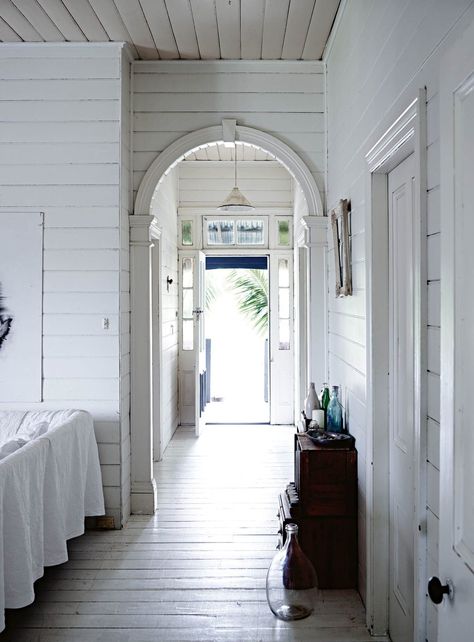 A traditional Queenslander home with all-white interior White On White Interiors, Old Queenslander Homes Interiors, Tranquil Bedroom, Blue Glass Bottles, Double Hung Windows, Aluminium Windows, Kitchen Bin, Iron Bed, Lined Curtains