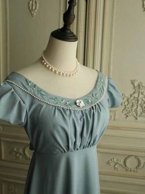 Experience the timeless elegance of the Regency era with this stunning grayish blue Bridgerton-inspired dress. Perfect for brides and special occasions, this dress beautifully blends vintage charm with modern sophistication. Timeless Design: Featuring a classic Regency silhouette, this dress boasts puffed sleeves and a gracefully flowing skirt. The floral appliqués and intricate beaded details along the neckline add a touch of refined elegance. Exquisite Details: The gown is adorned with delicate floral appliqués and beadwork, exuding sophistication and luxury. The back is tied with a ribbon belt, ensuring a flattering fit and adding to the dress's elegant design. Premium Quality: Made from high-quality fabric, this dress offers a soft and luxurious feel. The meticulous craftsmanship is ev Regency Silhouette, Regency Era Dress, Nontraditional Wedding Dress, Antoinette Dress, Wedding Dresses High Low, Floral Applique Dress, Champagne Evening Dress, Bridgerton Inspired, Fairy Wedding Dress