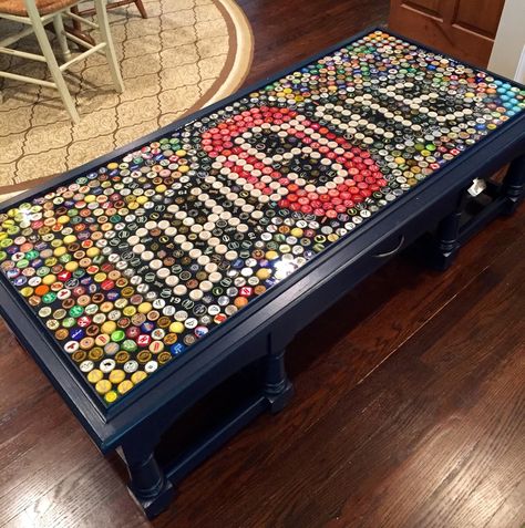 Here is Cal's Ohio State University Beer Cap Table...   (painted Goodwill table with top trim added to contain the caps and glaze)...complet... Beer Cap Projects, Beer Cap Table, Beer Bottle Cap Art, Beer Crafts, Beer Cap Art, Bottle Top Crafts, Bottle Cap Table, Bottle Cap Projects, Cap Art