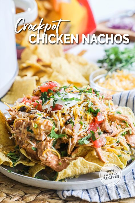 Plate of crockpot chicken nachos topped with cheese, lettuce, pico de gallo, and sour cream Crockpot Chicken Nachos Recipe, Chicken Nachos Crockpot, Crockpot Chicken Nachos, Creamy Crockpot Chicken, Chicken Nachos Recipe, Recipes Crockpot Chicken, Easy Nachos, Beans And Corn, Zesty Sauce