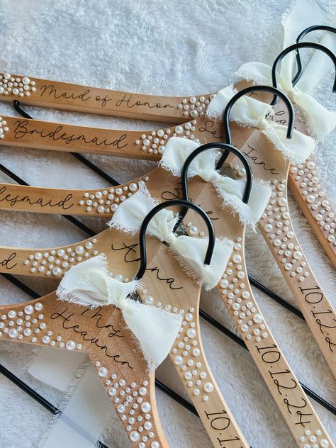 Our pearl hangers are elegant and stylish- made for displaying your wedding attire in style. Hangers are handcrafted to ensure that each piece is unique in its own way! Our hangers are laser engraved. Leaving the personalized name a dark brown color. With adhesive pearls added to create the elegant appearance. Pearls are completely optional to you! Our hangers are just as eye catching without the touch of pearls! We offer a few styles of elegant fonts for you to choose from, please view the last Gold Hangers Wedding, Bridesmaids Hangers, Pearl Hangers, Diy Wedding Hangers, Diy Hangers, Wedding Party Hangers, Bride Hanger Personalized, Pearl Hanger, Bridesmaid Hanger