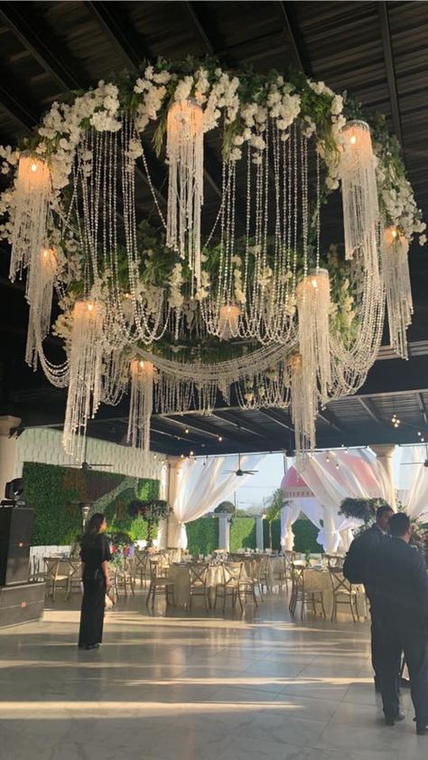 Have you ever seen anything like this? Our chandelier is a mixture of ivory hanging flowers, greenery leaves  and crystal beads followed by light that illuminates all around.  #Royalgarden #LuluJaramillo #Royalevents Crystal Hanging Decor Wedding, Chandelier Tent Wedding, Flowers Hanging From Ceiling Wedding, Hanging Flowers From Ceiling, Wisteria Chandelier, Flower Chandelier Wedding, Floral Chandelier Wedding, Bridal Suite Decor, Chandelier Flower