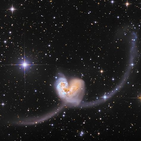 WASTED on Instagram: "The Antennae Galaxies (NGC 4038 and NGC 4039) collided gravitationally, forming a vast heart-like shape visible in space.   Located 60 million light years away, they have been merging for a billion years, triggering star formation through colliding interstellar gases.   Their iconic antennae structures and cosmic dance are expected to continue for another billion years." Two Stars Colliding, Galaxies Colliding, Colliding Galaxies, Stars Colliding, Heart Galaxy, Interstellar Space, Cosmic Dance, Astronomy Science, Sleep Token