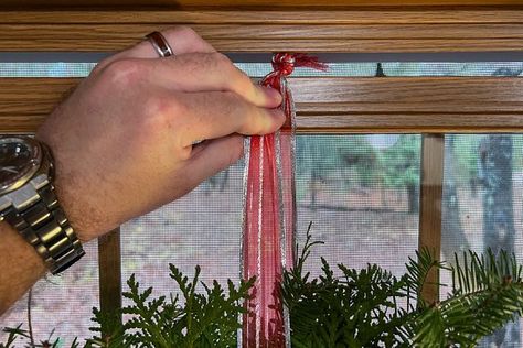 How To Hang a Wreath From a Window | Family Handyman Wreaths Over Windows With Blinds, Wreath Hanging From Ribbon In Window, Hanging Window Wreaths, Ribbon To Hang Wreath, How To Hang A Wreath On A Door, How To Hang Christmas Wreaths On Windows, Hang Wreath On Window, Hanging Wreaths On Windows With Ribbon, How To Hang A Wreath With Ribbon