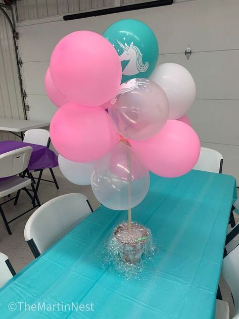 These DIY Balloon Topiarys are a quick and easy way to dress up your party tables / decor and add some height for visual interest.To begin, Blow up four balloons. Be careful not to overfill or they could pop during the assembly process.Tie the balloons together in sets of two.Then take two sets and twist their centers around each other multiple times. You'll end up with something that looks like this.In this image, there are three balloons at the base and one on top.Repeat this proce… Diy Balloon Centerpieces Easy, Diy Balloon Topiary, Proper Height For Balloons On Table, Balloon On A Stick Centerpiece, Balloon Table Centerpieces Diy, Tie Balloons Easy Way To, Table Top Balloon Centerpieces, Balloon Table Top Center Piece, Balloon Centerpieces Diy No Helium Center Pieces Table Decorations