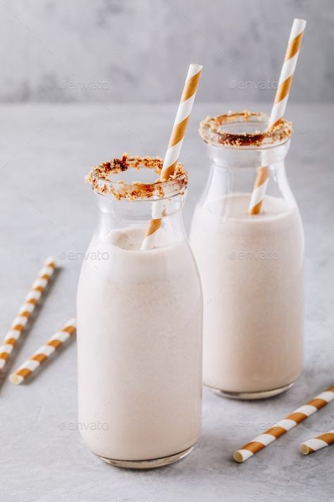 Vanilla milkshake in glass bottles on a gray background Vanilla Background, Milkshake Glasses, Cookie Milkshake, Milkshake Machine, Ramos Gin Fizz, Ice Cream Shake, Smoothie Straw, Vanilla Milkshake, Gin Fizz