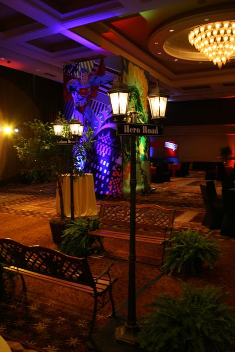 Superhero VS Villain themed event with Custom Murals, signage, lighting and vingettes #FLeventdecor Heroes And Villains Party Decorations, Fantasy Costumes For Comic-con Themed Events, Superhero Stage Design, Neon Superhero, Superhero Gala, Superhero Event, Spirit Week Ideas, Hoco Dance, Auction Decor