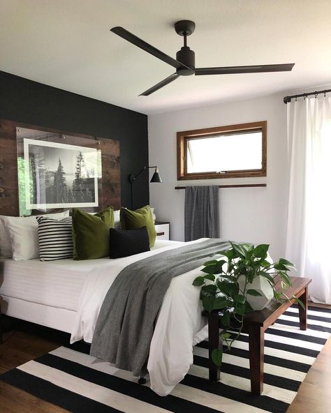 Homeowners looking for a sleek and minimalistic aesthetic, your search is over. This beautiful monochrome bedroom features a gorgeous jet-black accent wall with a rich mahogany headboard. A classic pairing of black and white presented by the walls is mimicked by the striped rug underneath the bed. Gray Accent Wall Bedroom, Moody Master, Black Accent Wall, Monochrome Bedroom, Black Accent Walls, Bedroom Accent, Accent Wall Bedroom, Cherry On Top, Remodel Bedroom