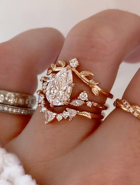 Harmony is a whimsical rose gold engagement ring that embodies the perfect balance of nature-inspired elegance and vintage charm. Our Adelixa acts as her leafy crown with a pop of sparkle. Kya completes this stack with her collection of trillion and round cut diamonds, and a dainty leaf engraving sits on either side to tie in an element of nature. Drop-down diamond options represent our recommended grade, which maximizes size for value, while maintaining eye-perfect clarity and giving you a colorless look. For other diamond options, see our Shop Diamonds tab or speak to one of our design consultants. This design can also be made with other stone shapes. Rings in this set can be purchased separately by visiting the individual product pages. Harmony's setting only cost: 14k Rose, White, or Y Vintage Wedding Rings Set, Dream Wedding Ring Rose Gold, Rose Quarts Engagement Ring, Whimsical Ring Engagement, Engagement Rings Butterfly, Mexican Engagement Ring, Vintage Engagement Ring Set, Vintage Ring Designs, Heart Shape Ring Design Gold