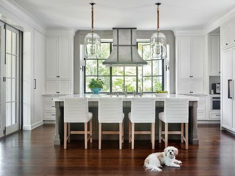 Beautiful white cottage kitchen features four white striped leather counter stools placed at a gray island donning a white marble countertop lit by rope and glass dome light pendants. Hood In Front Of Window, White Cottage Kitchen, Concrete Stool, Kitchen Hood, Kitchen Cabinet Styles, Interior Windows, Kitchen Hoods, White Marble Countertops, Atlanta Homes