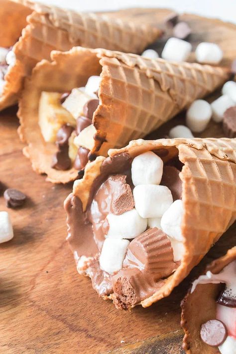 These Waffle Cone Smores are a fun treat any time of year. A summer twist on a fall treat or a fall twist on a summer treat – You decide! These Waffle Cone Smores are a delicious treat whichever way you cook them, but let's be honest - it's most fun to cook on the grill! Waffle Cone Smores, Cone Smores, Campfire Cones, Waffle Cone, Waffle Cones, Fall Treats, Fun Treats, Treat You, On The Grill