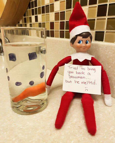 "Elf On The Shelf idea with an elf holding a sign saying 'Tried to bring you back a snowman... but he melted,' next to a glass with drawn snowman features." Elf On T He Shelf Ideas, Elf On Shelf Messy Ideas, I’m Back Elf On The Shelf Ideas Easy, Elf On The Shelf I'm Back Ideas, Elf On The Shelf Slumber Party, Elf On The Shelf Ideas Snowman, Elf On The Self I’m Back Ideas, Easy I’m Back Elf On The Shelf, Elf I’m Back Ideas