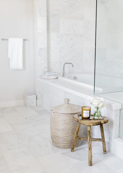 White and gray master bathroom decorated with a woven hamper and a rustic wooden stool beside a marble-tiled drop in bathtub. Small Wooden Stool, Bath Stool, Bathroom Stool, Rustic Bathroom Designs, Transitional Bathroom, Wooden Stool, Bathroom Floor Tiles, Luxury Towels, Bath Room