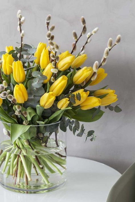 a clear vase with yellow tulips and willow plus a bit of eucalyptus is a lovely and bold spring flower arrangement Easter Flower Arrangements, Tulips Arrangement, Deco Champetre, Spring Flower Arrangements, Spring Arrangements, Spring Floral Arrangements, Flower Vase Arrangements, Tulips In Vase, Tulip Bouquet