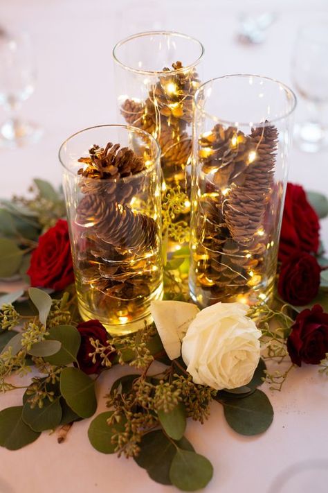 a cute Christmas wedding centerpiece Winter Wedding Pinecones, December Wedding Table Centerpieces, Pinecone Wedding Decor, Pinecone Wedding Centerpiece, Twinkle Lights Centerpiece, Pinecone Centerpiece Wedding, Winter Centerpieces Wedding, Winter Wedding Centerpieces Elegant, Fairy Lights Centerpiece