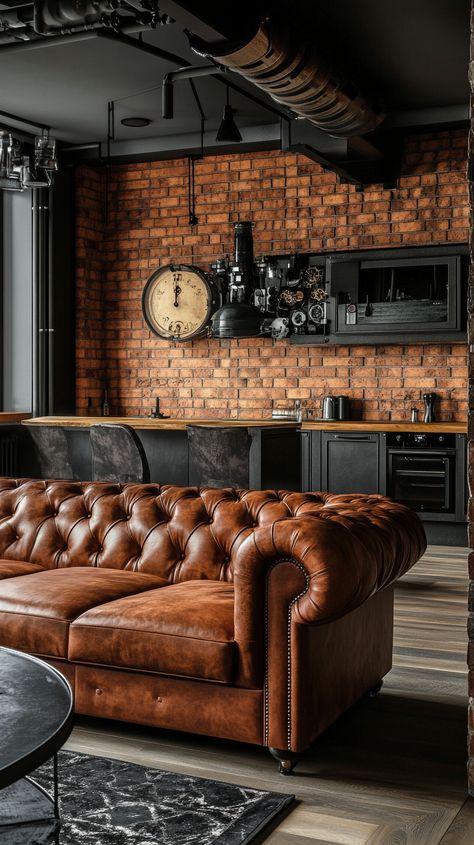 Cozy industrial-style living room with a brown leather Chesterfield sofa, brick walls, wood accents, and a steampunk kitchen Leather Tuffed Couches, Industrial Cozy Living Room, Red Brick Wall Living Room, Leather Brown Couch, Brown Apartment Aesthetic, Chesterfield Sofa Living Room Ideas, Tufted Couch Living Room, Cognac Leather Couch Living Rooms, Light Brown Leather Couch