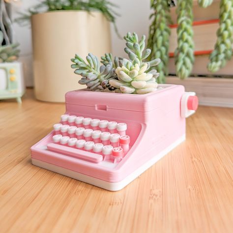 ⌨️ Retro Typewriter Succulent Planter  This cute bubblegum pink-colored succulent planter is a unique housewarming gift for plant lovers--or a great addition to your own houseplant collection. It makes a cute desk accessory or is right at home on a sunny bookshelf, whether you're into funky retro decor, a cozy maximalist aesthetic, or even have a more minimalist take on things. As longtime plant parents, we had to make a planter that ticked all the boxes:  🙌 a planter with drainage  🫗 a perfect-fit drip tray 🪴and a removable inner pot for easy planting The only thing not included is a live plant, so happy hunting for the perfect plant match! We'd love to see what you pair your new planter with. 🚨 Get 15% off your first order when you sign up to our email list: 𝘀𝘂𝗯𝘀𝗰𝗿𝗶𝗯𝗲𝗽𝗮𝗴? Funky Retro Decor, Baddie Decor, Pink Kitchen Aesthetic, Cute Pots For Plants, Cute Plant Pots, Cute Cubicle, Aesthetic Desk Decor, Retro Gift Ideas, Cute Vase