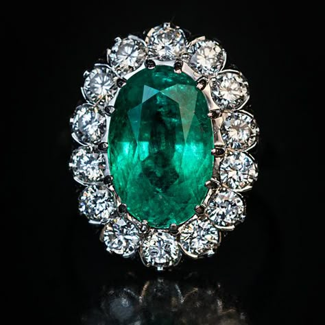 This mid-century vintage French emerald and diamond engagement cluster ring is finely crafted in platinum (head) and 18K white gold (shank). The ring features a sparkling medium green natural emerald likely of Colombian origin.  The oval cut emerald measures 12.62 x 8.15 x 6.30 mm and is approximately 3.59 ct.  The brilliant cut diamonds are bright white (E-F color) and clean (mostly VS clarity). Estimated total diamond weight is 1.40 ct.  The ring is marked with eagle’s head and dog’s head Fren Emerald Diamond Engagement Ring, Jewelry Closet, Diamond Tops, Emerald Ring Engagement Diamond, Emerald Ring Vintage, Luxury Engagement Rings, Faberge Eggs, Engagement Ring Diamond Cut, Emerald Jewelry