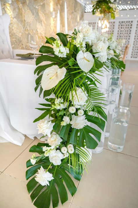 A glamorous and romantic choice for this wedding was monstera with white anthurium and white roses | Shannon and Rodney's wedding at Kukua Punta Cana | Dominican Republic | Wedding photography and video by Milan Photo Cine Art #wedding #weddingreception #weddingdecoration #weddingflowers #tropicalweddingdecor #anthuriums #weddinginspiration #weddingdecor #decor #weddingideas #weddingflorist #weddingdetails #whiteroses #weddinginspo #weddingday #kukuapuntacana #milanphotocineart #photocineart Wedding Tropical Centerpieces, Anthurium Centerpiece, Monstera Wedding Decor, White Tropical Flower Arrangements, Tropical Flowers Wedding, Tropical Flower Arrangements Diy, White Anthurium, Tropical White Flowers Wedding, Tropical Wedding Flowers Centerpieces