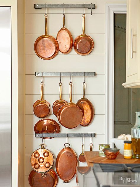 Industrial stainless-steel racks hold a collection of vintage copper pots. The contemporary mix of metals elegantly contrasts with this kitchen's traditional-style wood-plank walls. Hang Pots And Pans, Copper Pots And Pans, Pallet Deck Diy, Vintage Copper Pots, How To Clean Copper, Timeless Kitchen, Deco Retro, Copper Pots, Pot Rack