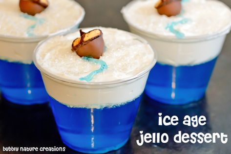 Ingredients: 1 pkg of blue colored jello  whipped cream   sprinkles  blue gel icing  9 oz. clear plastic cups  edible glitter or sanding sugar in white color  mini acorns  Instructions: Make the jello. Fill the cups with the jello and let it set. Once the jello is firm and completely set, top it with whipped cream. Make a zig zag line in the middle with the blue gel and place a mini acorn cookie in the middle. Sprinkle with sanding sugar or edible glitter for a snow look. Enjoy! Diy Hot Cocoa Mix, Ice Age Birthday Party, Ice Age Cake, Christmas Gifts Diy Homemade, Hot Cocoa Ornaments, Acorn Cookies, Jello Dessert, Homemade Christmas Gift, Diy Hot Cocoa