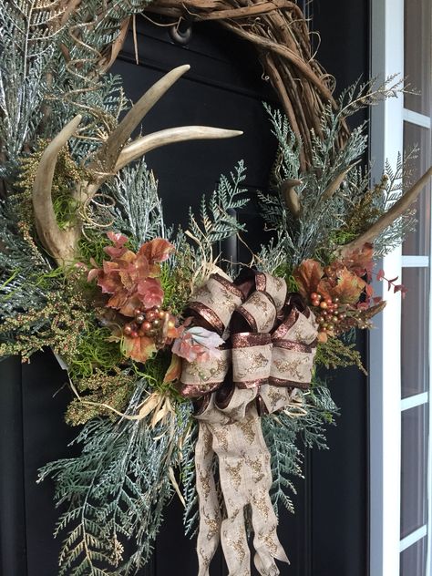 Rustic fall or winter wreath with antlers in a grape vine wreath with Green pines...grasses...leaves...and deer ribbon bow Wreath With Deer Antlers, Rustic Christmas Mantel, Antler Ideas, Antler Wreath, Rustic Christmas Wreath, Deer Decor, Tree Wreath, Pine Wreath, Trend 2024