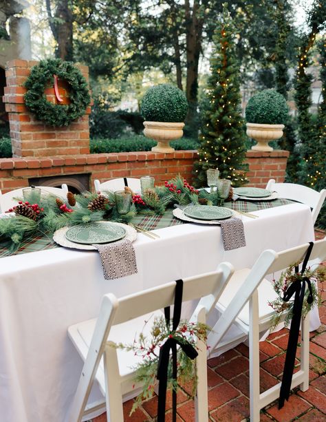 An outdoor patio with Christmas tree and fireplace set with a white table and chairs set with evergreen decorations for a holiday brunch. Evergreen Decorations, White Table And Chairs, Cranberry Cider, Eggnog French Toast, Christmas Tree And Fireplace, Outdoor Gathering Space, Family Dishes, Christmas Eve Dinner, Fireplace Set