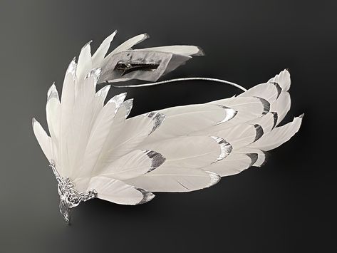 A unique tiara made from a natural feather, coated with liquid plastic at the ends and painted with chrome-plated silver paint. The center of the crown is decorated with a metal element with a pendant. This headpiece will complement any White Swan, White Raven, White Eagle, Firebird, Bird of Paradise, Phoenix or Goddess costume you desire. It will be a great addition to a photo shoot, festival or party, Halloween party. The headpiece is attached to the hair with hair clips and elastic band. The White Swan Headpiece, Feather Costume Ideas, Feather Headpiece Diy, Raven Headpiece, Swan Lake Headpiece, Swan Costume Diy, Unique Crowns, Swan Headpiece, Bird Headdress