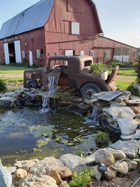 Old Truck Fountain, Rustic Pond Ideas, Truck Water Feature, Farm Yard Landscaping Country Living, Old Truck Water Fountain, Farmhouse With Pond, Truck Waterfall, Front Yard Pool, Rustic Fountain