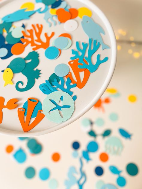 Create a fun atmosphere with this Under the Sea confetti. Just sprinkle party confetti on tables and surfaces, or add to party invitations, favour bags for a sparkling surprise. This is a great way to add simple but stunning details to brighten up your baby boy first Birthday and Baby Shower party.Designed to matching Under the Sea, Ocean theme, Onder the Sea, Ocean Animals Birthday or Baby Shower party perfectly.--COLOR--• Dark blue, Orange, Mint, Yellow, Teal, Blue-- DETAILS-• Sea animals decorations made of high quality design paper• Available in sets of 100pcs, 200pcs and 300pcs• You will receive in the pack of 100 pcs: sea animals: seahorse, crab, starfish, whale, fish, octopus, jellyfish, shark, sea shells + two size mix circles• Under the Sea table confetti is made carefully and acc Sea Animals Party, Under The Sea Party Ideas, Shark Themed Party, Whale Fish, Ocean Theme Birthday, Ocean Birthday, Sprinkle Party, Baby Birthday Themes, Sea Baby Shower