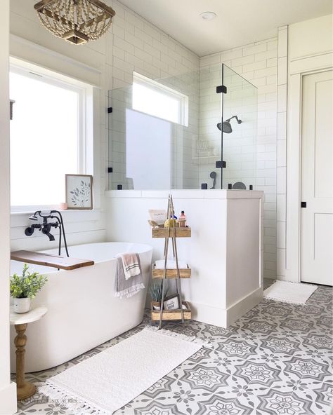 A bathtub black faucet is mounted on a white shiplap tub surround above a white freestanding oval tub. The tub sits beside a glass walk-in shower with white staggered wall tile in this bathroom with white and gray mosaic floor tiles. Half Wall Shower Ideas, Stand Alone Bath Tub, Half Wall Shower, Showers Without Doors, Doorless Shower, Farmhouse Shower, Bathroom Redesign, Master Bath Remodel, Bathroom Remodel Designs