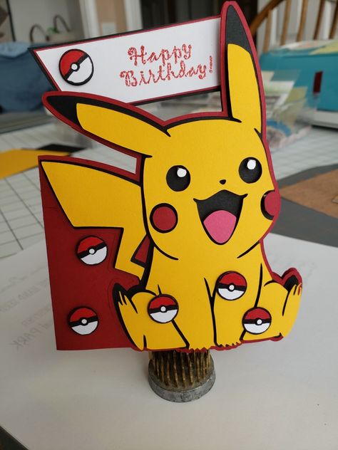 Pikachu from freesvg. Using Cricut DS created offset edge card. Balls are white cs punched out and hand colored. For dimension popped balls and top Pikachu layers with dots. Pokemon Cricut Card, Pokemon Birthday Card Ideas, Pikachu Birthday Card Diy, Pikachu Cards Diy, Pokémon Birthday Cards, Pokemon Birthday Cards, Pokemon Cricut, Happy Birthday Pokemon, Pikachu Card