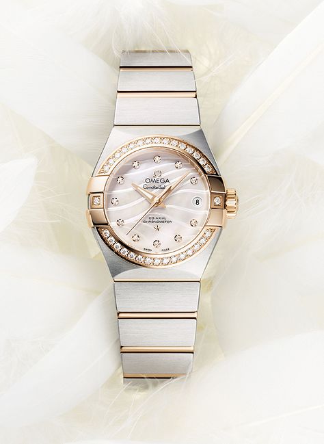 The Omega Constellation Pluma has a mother-of-pearl dial, in natural white or blue, which features an engraved, wavy pattern that recalls the shapes of a feather (“Pluma” is Latin for “feather”). The white-dialed model has a bezel in 18k rose gold and 18k rose gold links in the steel bracelet. Omega Chronograph, Omega Watch Women, Swiss Army Watches, Armani Watches, Omega Constellation, Vintage Omega, Vintage Watches For Men, Womens Watches Luxury, Fine Watches